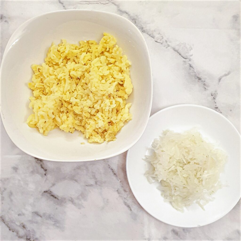 Two dishes, one containing grated baked potato and the other containing grated onion.