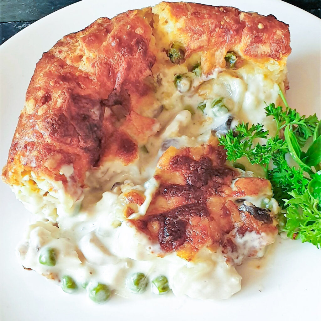 A slice of chicken and mushroom gougere pie on a plate.