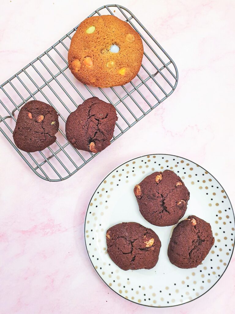 Small chocolate flavoured Smartie cookies on ahttps://www.w3.org/WAI/tutorials/images/decision-tree plate next to a giant Smartie cookie.