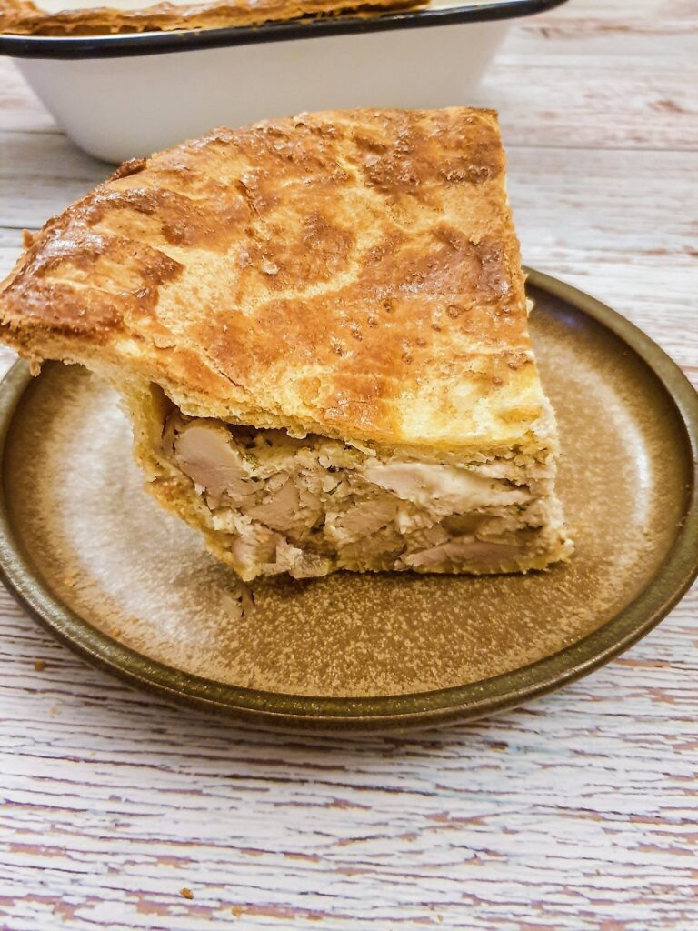 A slice of chicken pie on a plate.