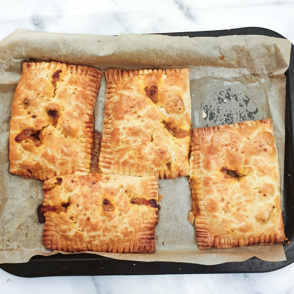 4 baked pies on a baking tray.