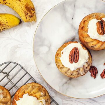 Two bundt cakes on a plate next to two bananas.