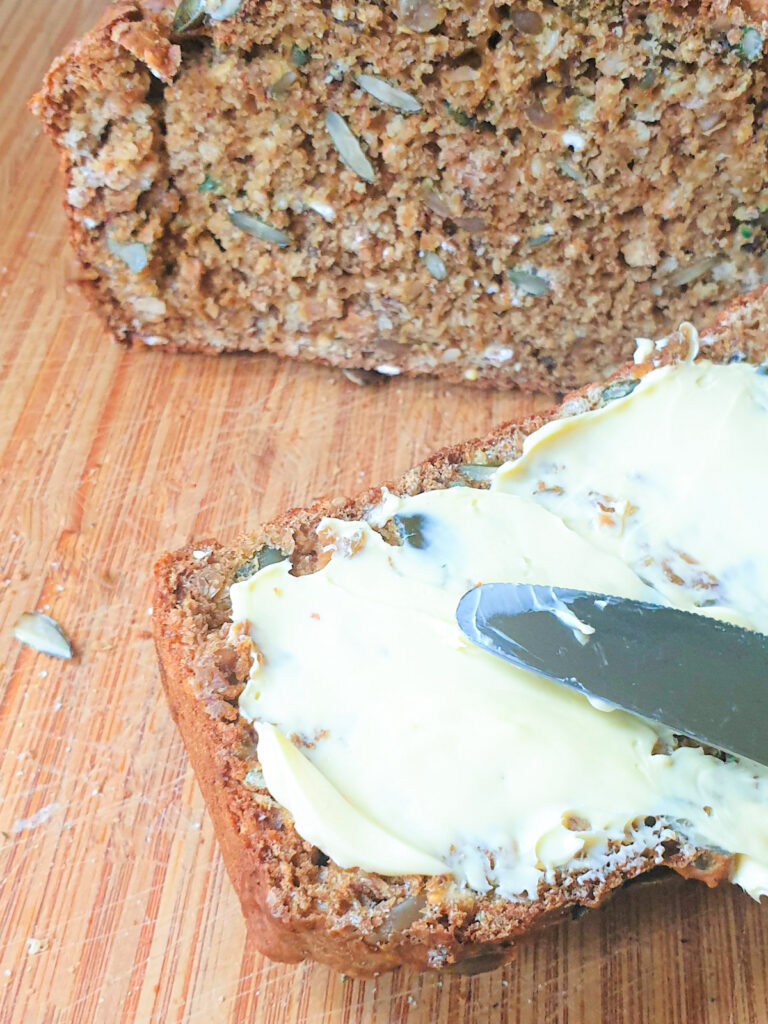 A slice of irish soda bread being buttered.