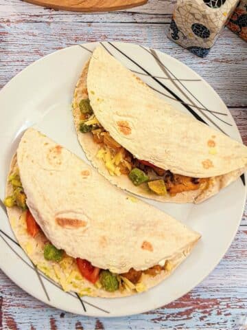 2 folded chicken fajitas on a plate.