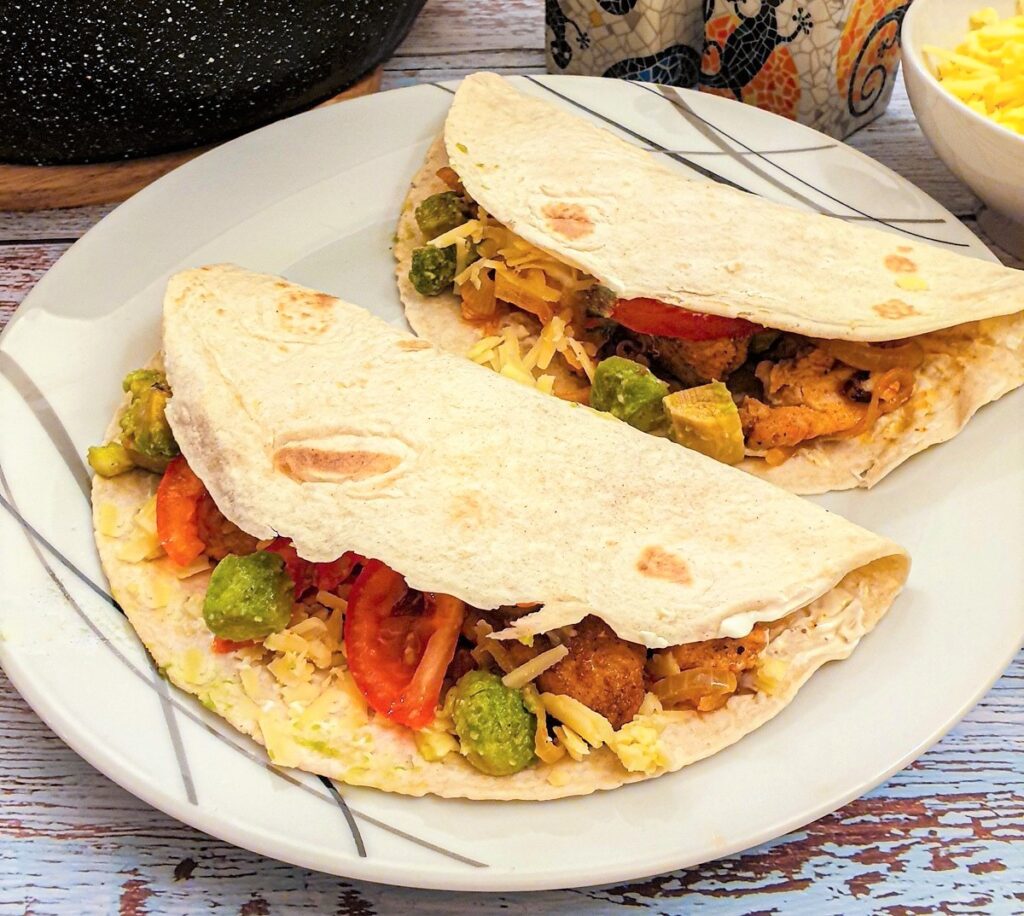 Close up of 2 fajitas on a plate.