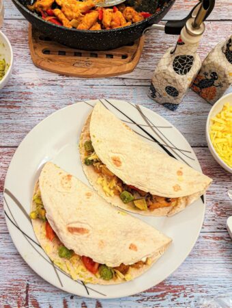 Two fajitas on a plate.