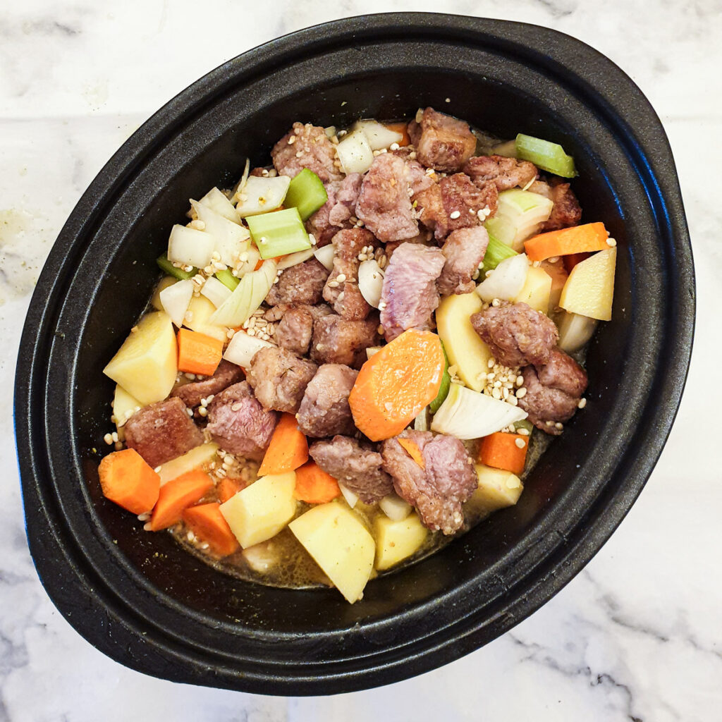 Meat and vegetables in a slow cooker.