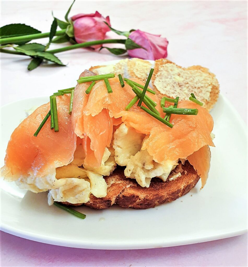 Scrambled eggs on a slice of toast, topped with sliced smoked salmon and garnished with chopped chives. Scrambled eggs on a slice of toast, topped with sliced smoked salmon and garnished with chopped chives.