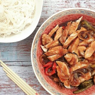 A serving dish of teriyaki chicken with a bowl of noodles.