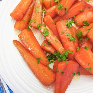 A plate of glazed carrots sprinkled with parsley.