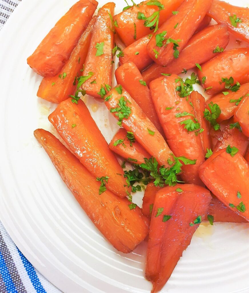 A plate of glazed carrots sprinkled with parsley.