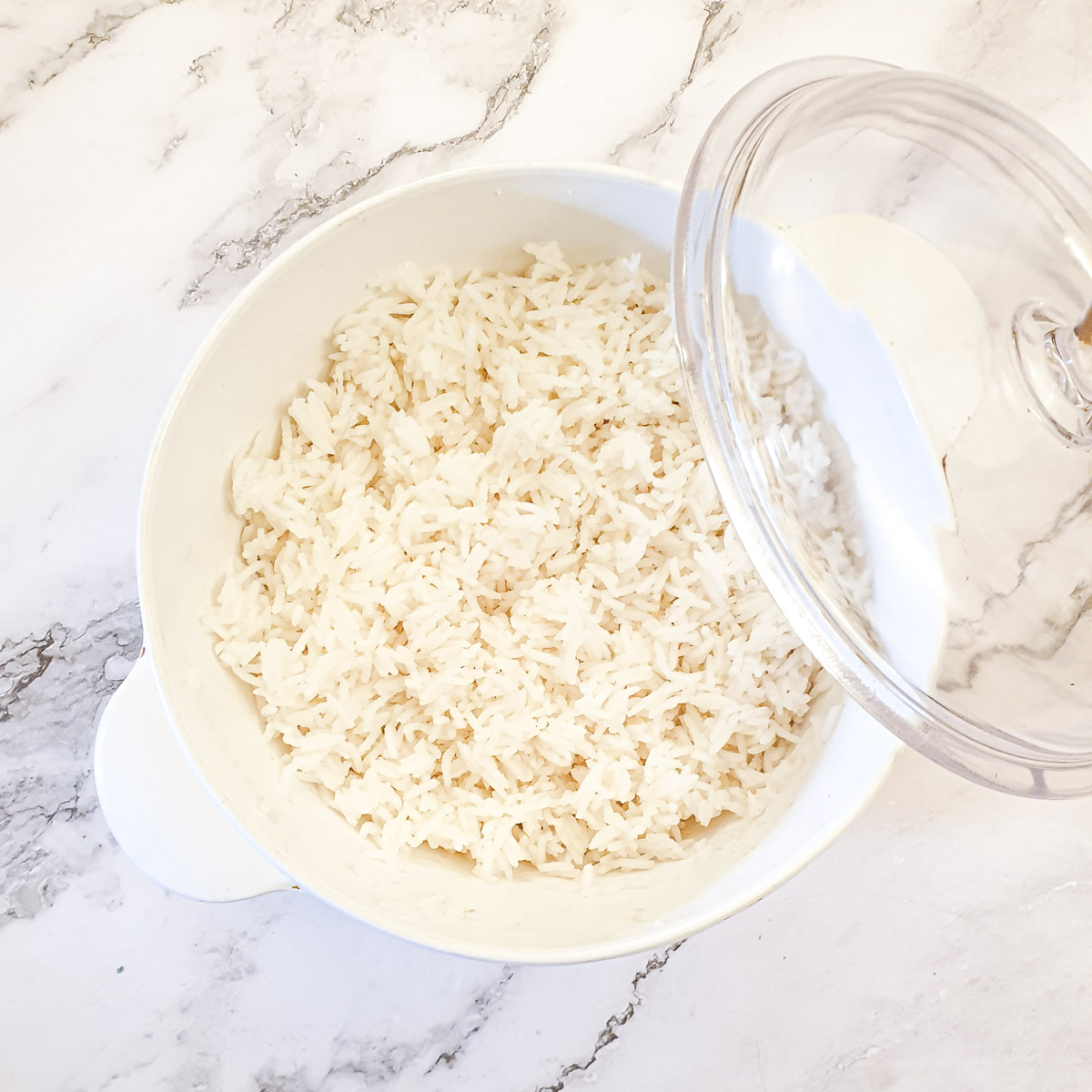 A pyrex dish filled with rice cooked i the microwave.