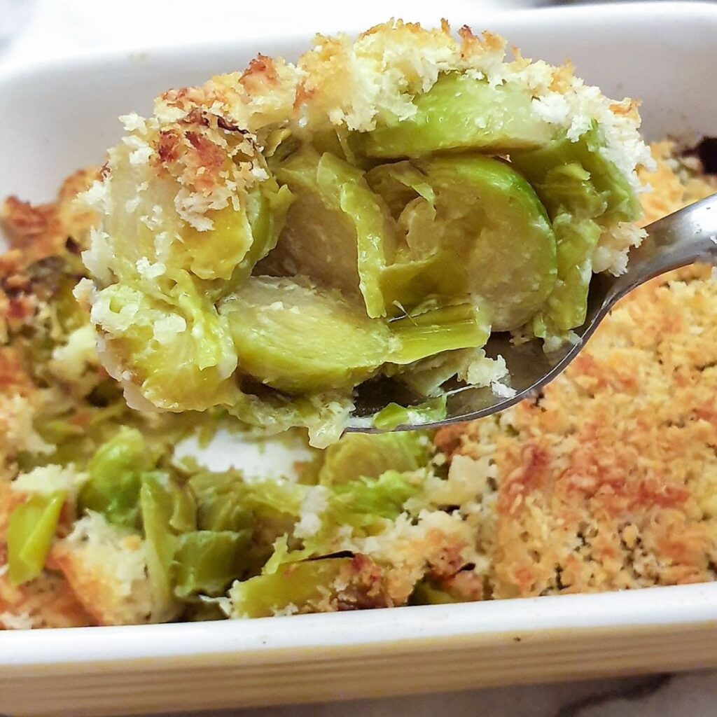 Close up of the brussels sprouts and leeks on a spoon.