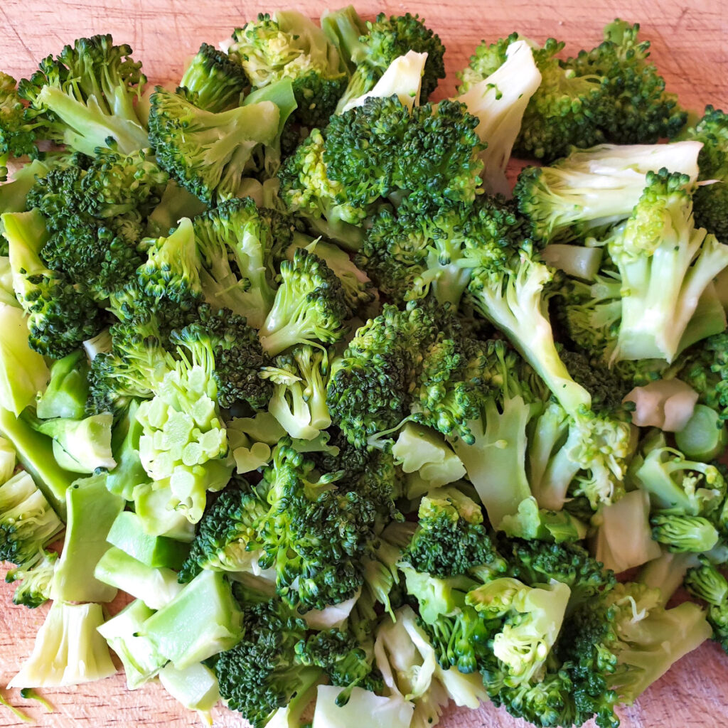 A pile of cooked broccoli cut into small pieces.