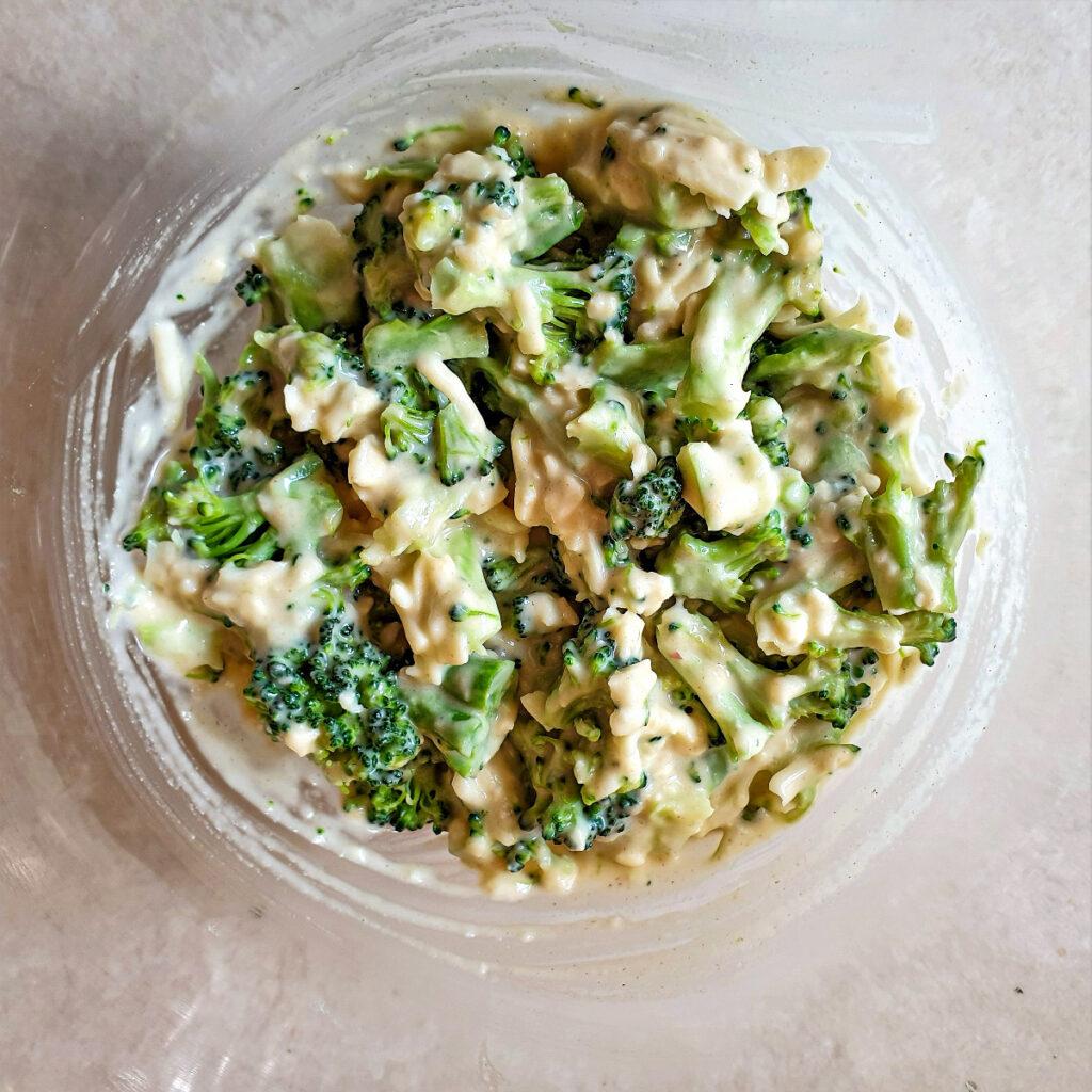 A bowl of broccoli and cheese mixed with eggs and flour.