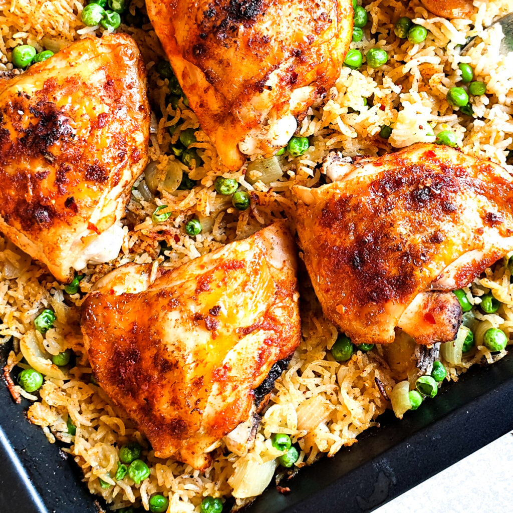 Garlic chicken bake in a roasting dish with a spoon.