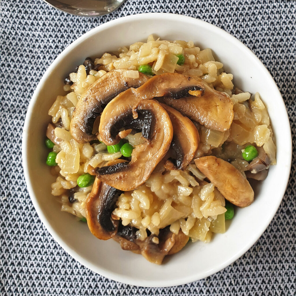 Overhead shot of a bowl of mushroom and pea risotto.