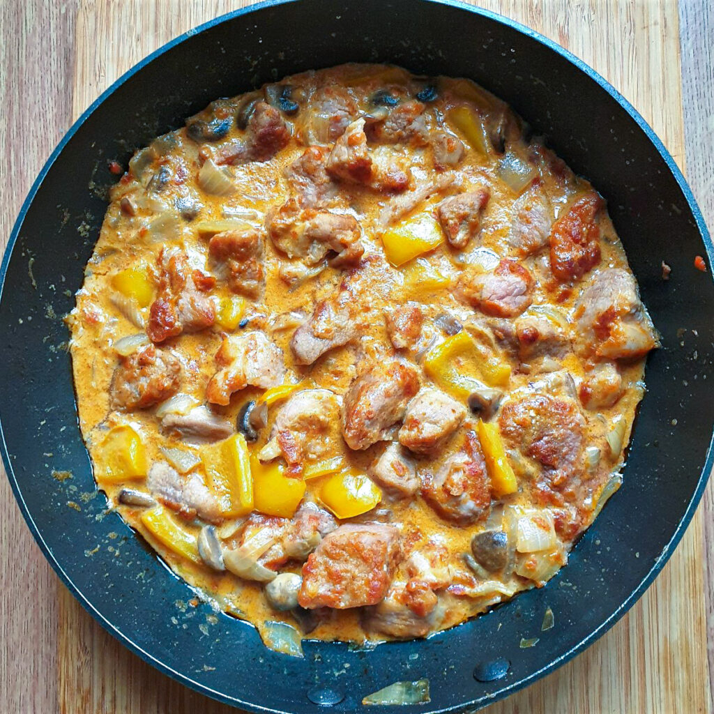 A pan of pork pieces in paprika sauce.