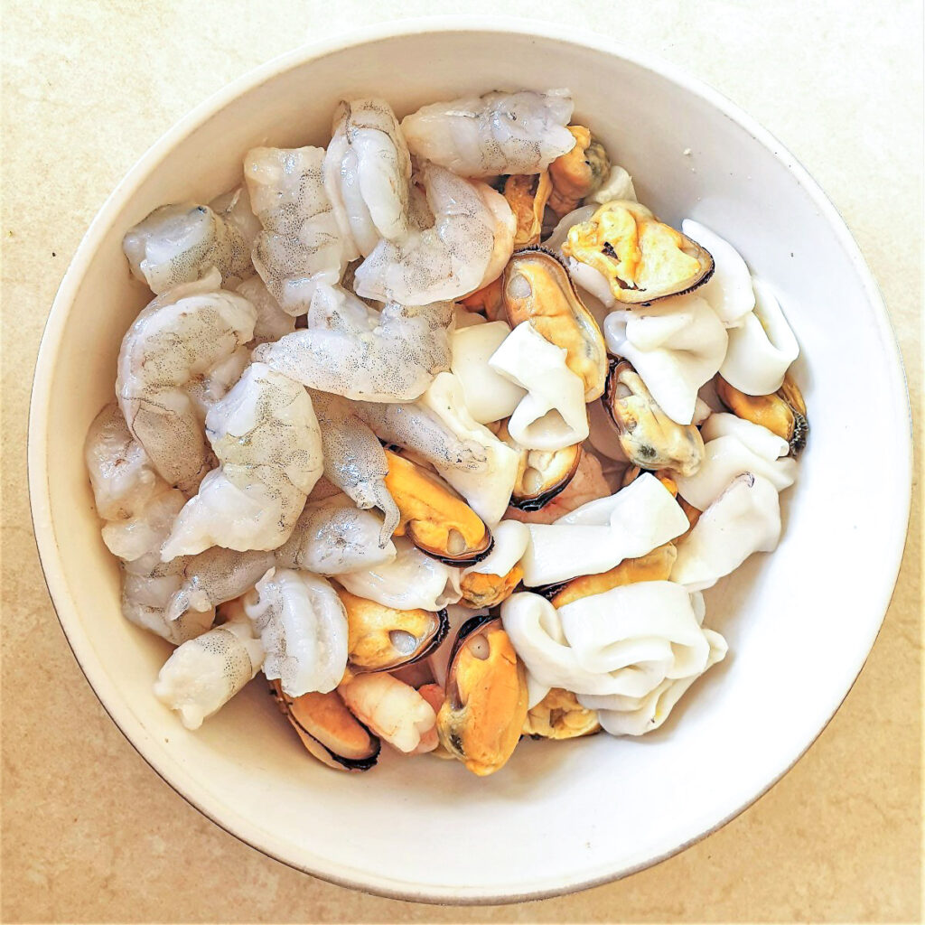 A white bowl filled with seafood.