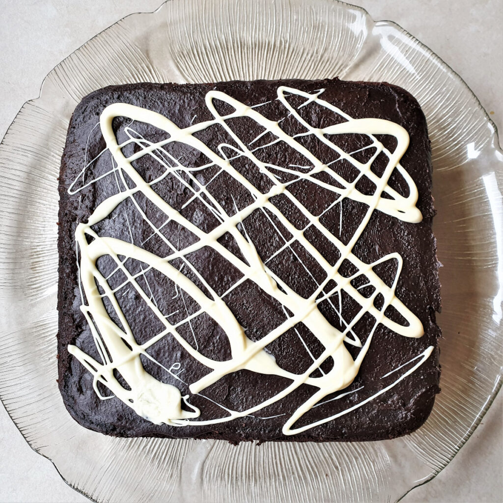 The chocolate cake decorated with drizzles of white chocolate.