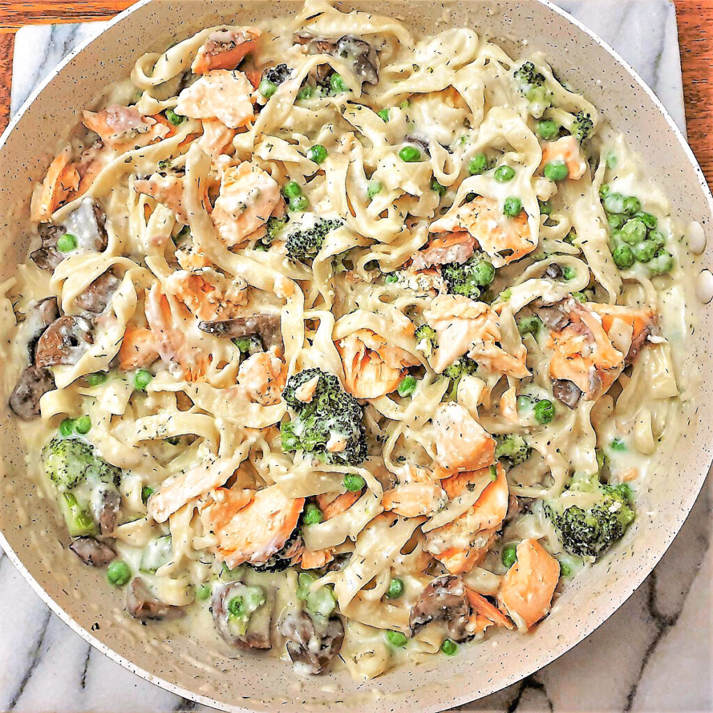 Salmon and broccoli pasta in a frying pan.