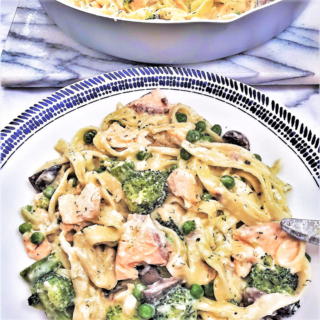 A plate of salmon and broccoli pasta