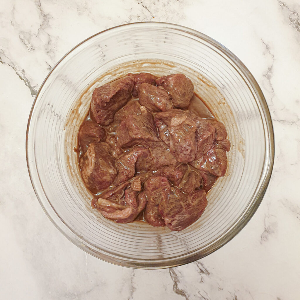 Pieces of beef marinating in a mixture of cornflour and Worcestershire sauce.