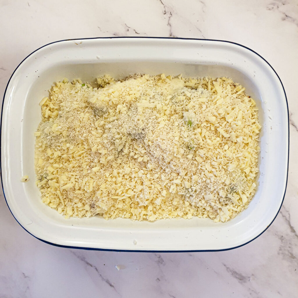 The completed dish sprinkled with cheese and breadcrumbs ready for the oven.