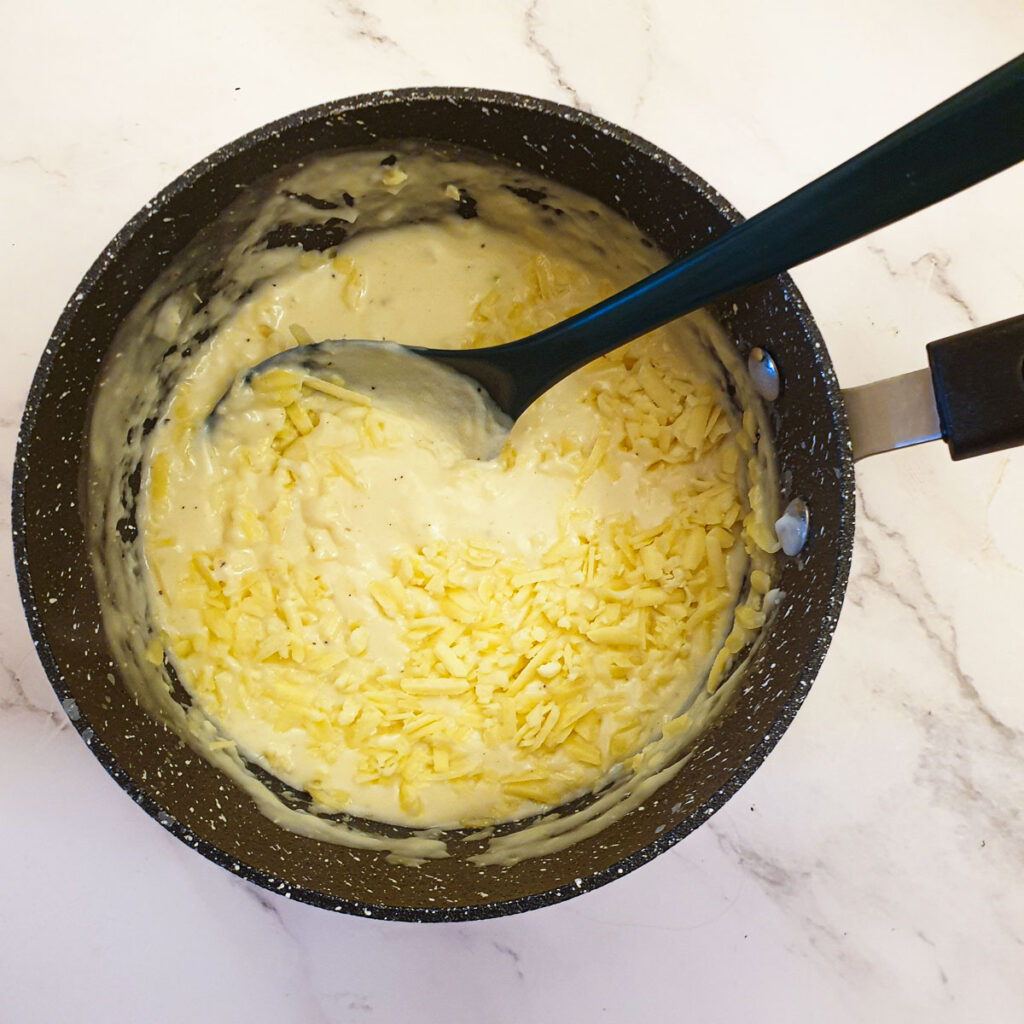 Grated cheese being added to the sauce.