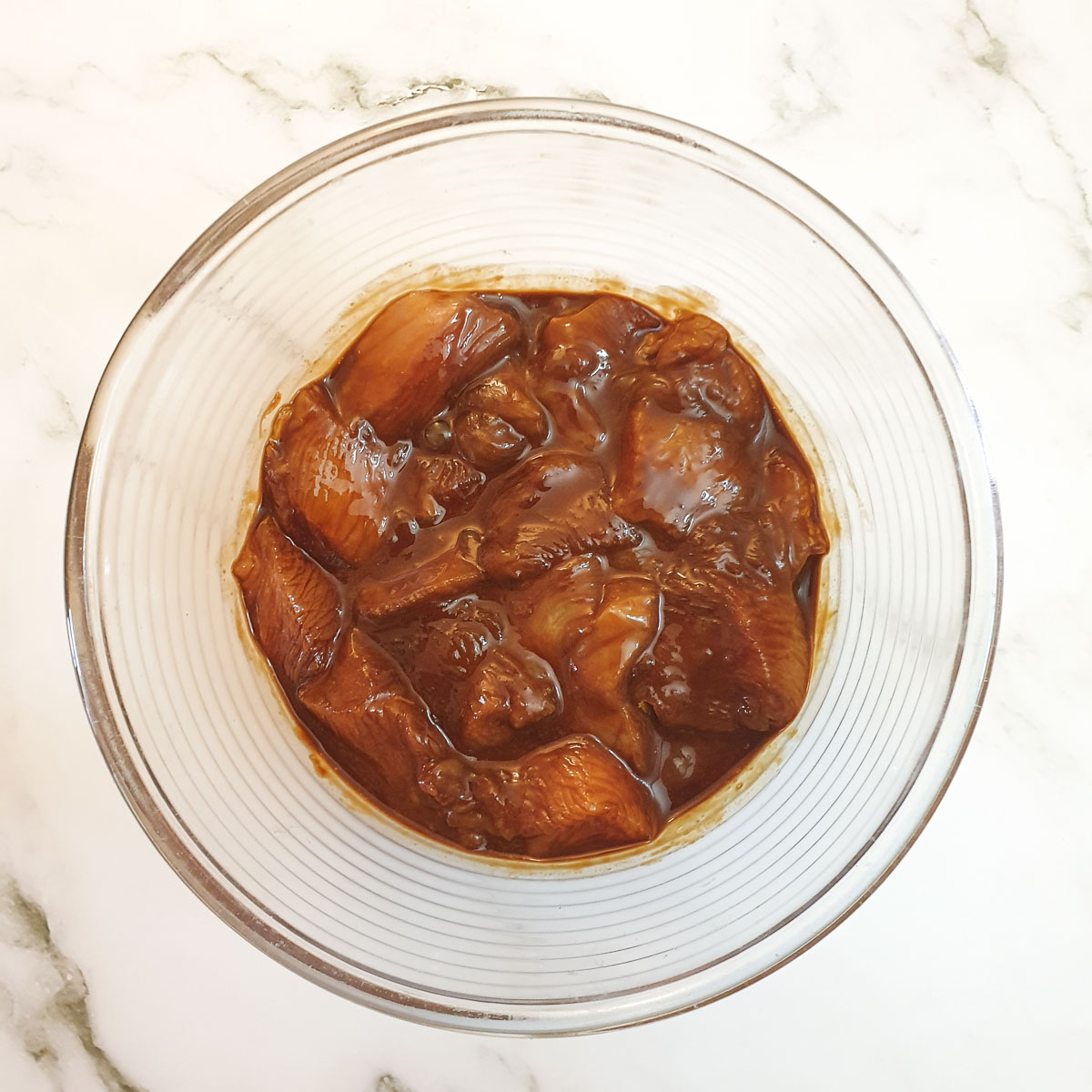 Chicken pieces marinating in soy sauce and cornflour.