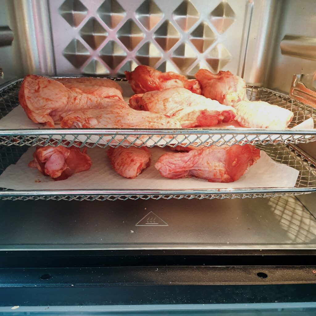 Chicken wings on the trays in an air-fryer oven.