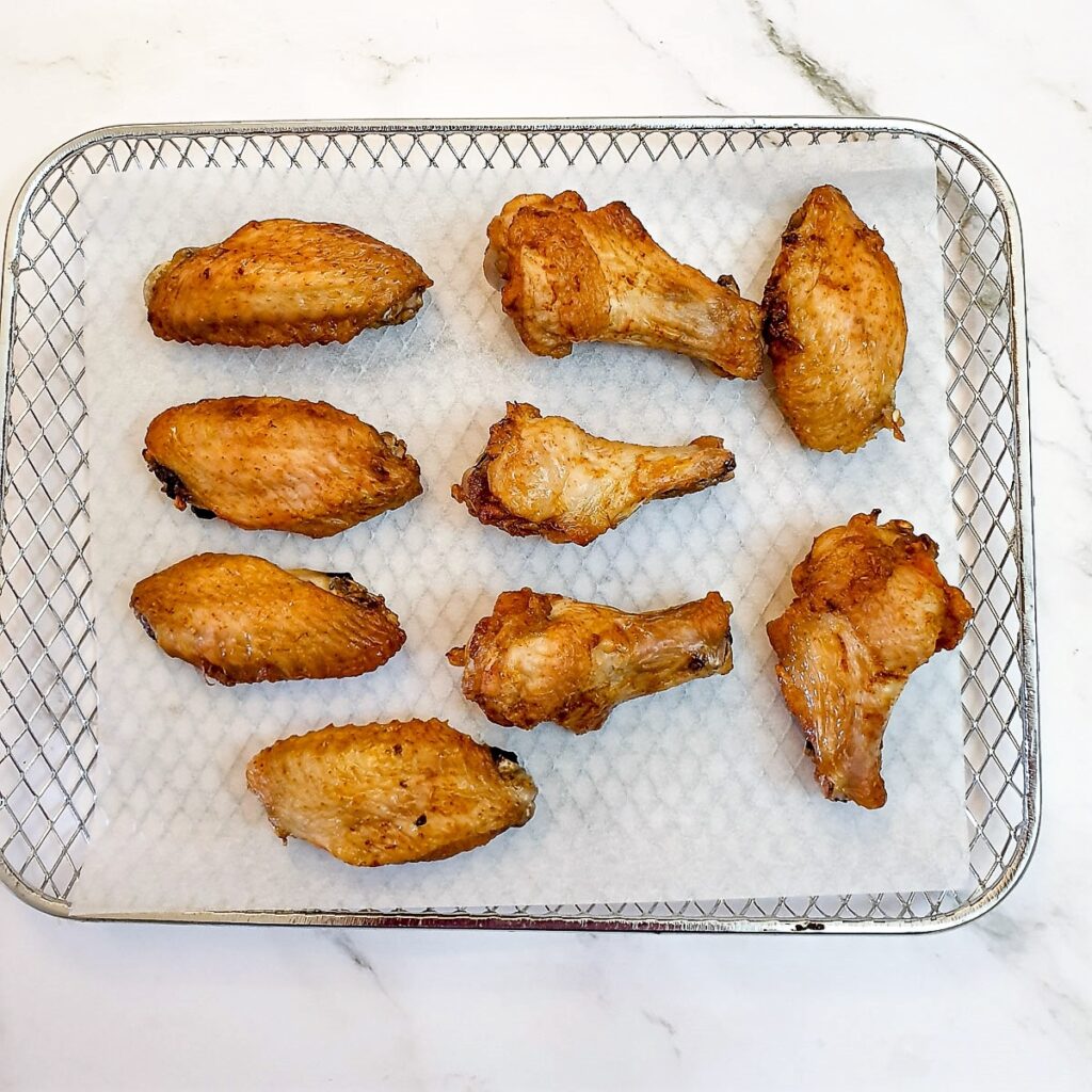 Golden brown air-fried chicken wings on a baking tray.