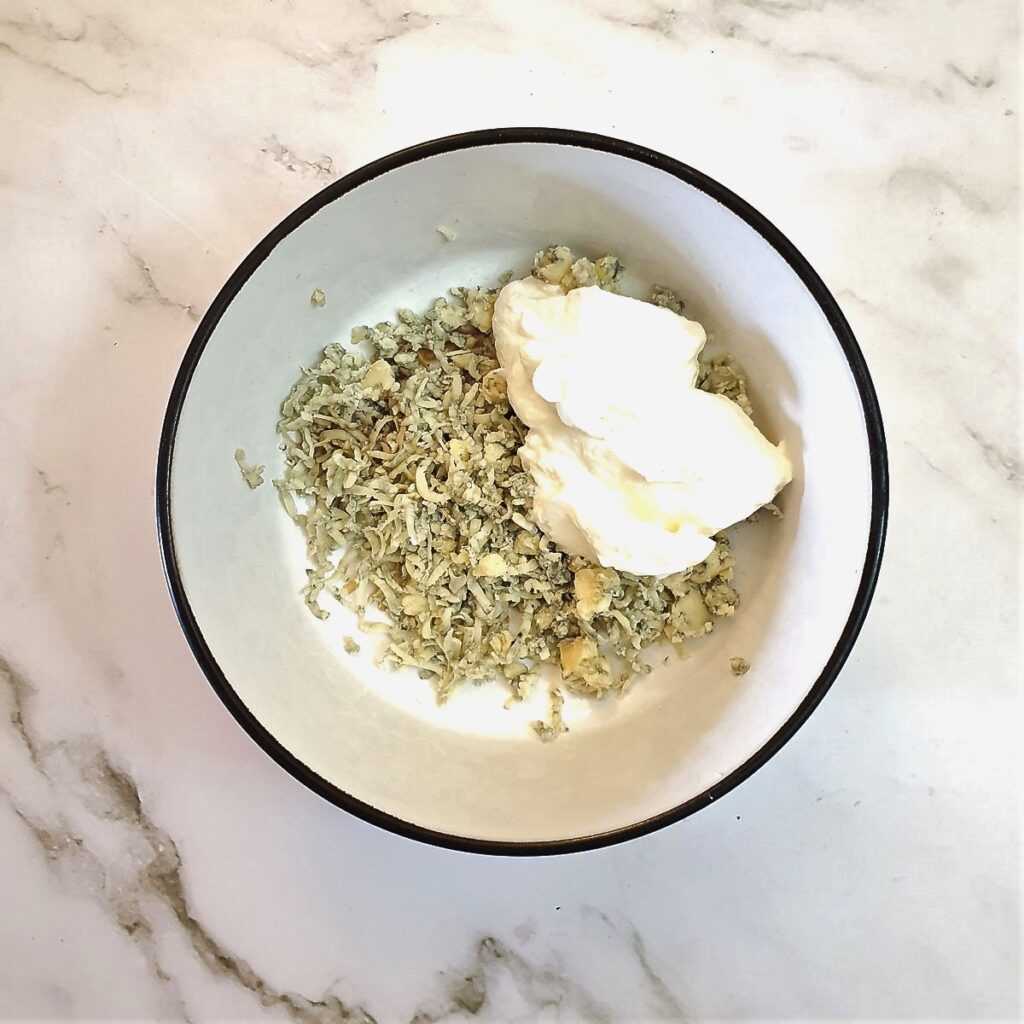 Ingredients for blue cheese sauce in a small mixing bowl.