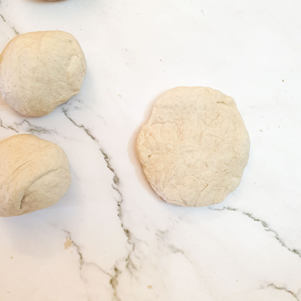 One of the 12 balls of dough being flattened.