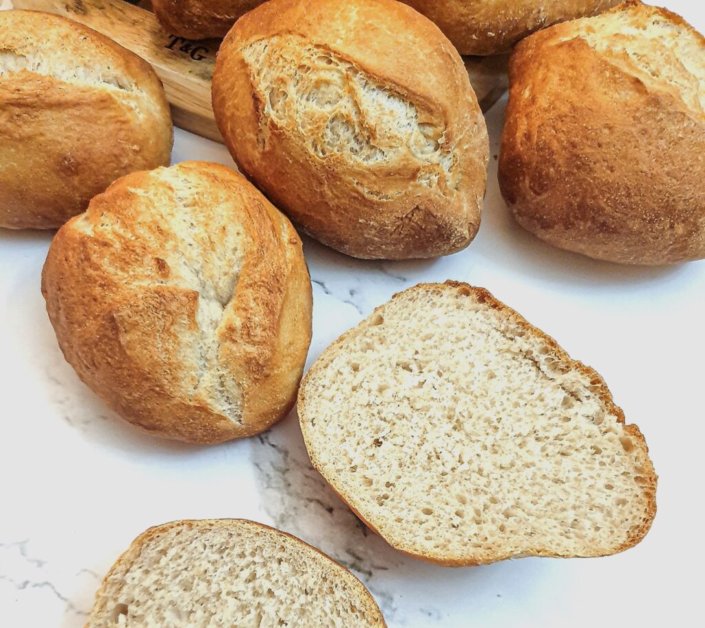 A crusty German bread roll cut in half to show the inside.