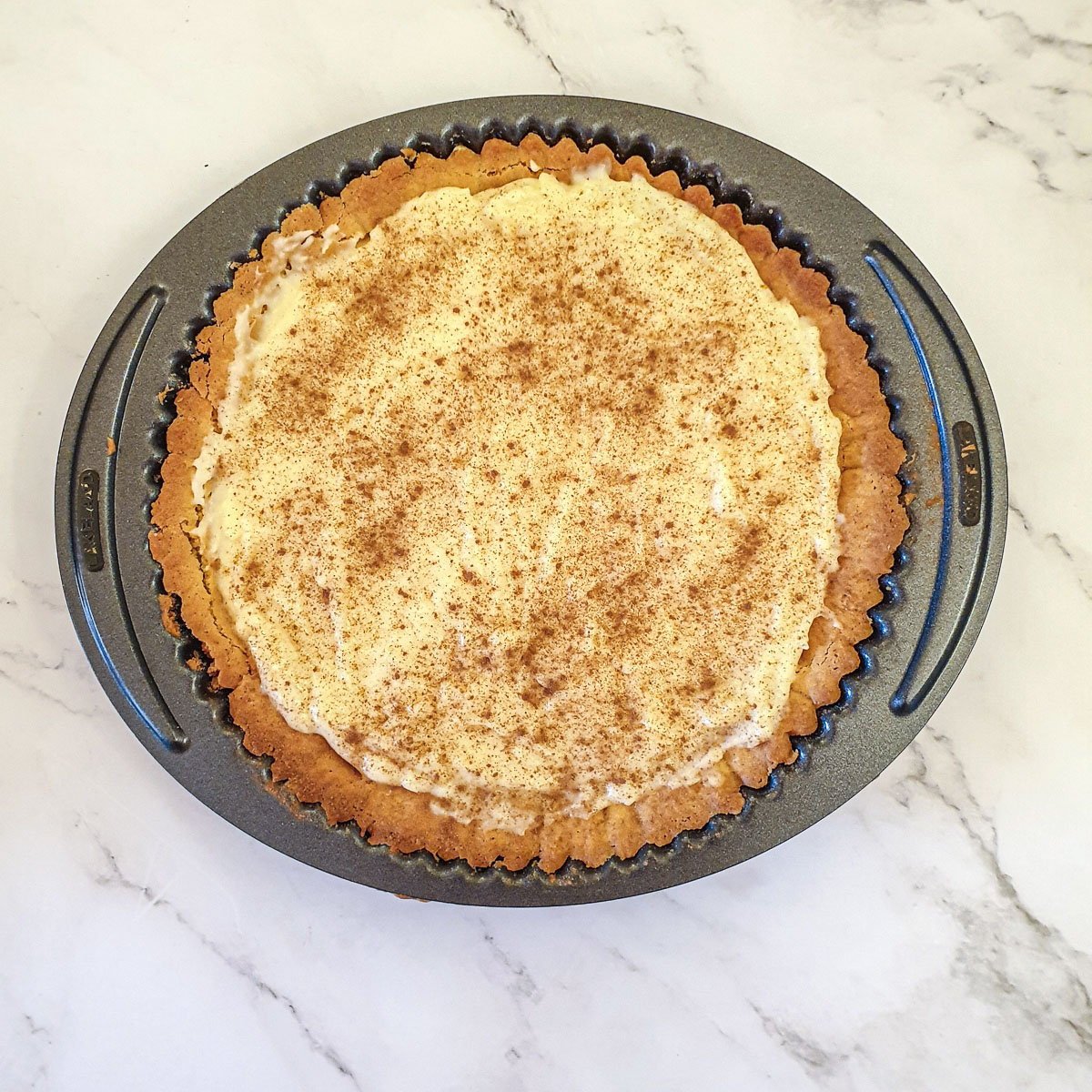 The completed milk tart sprinkled with cinnamon