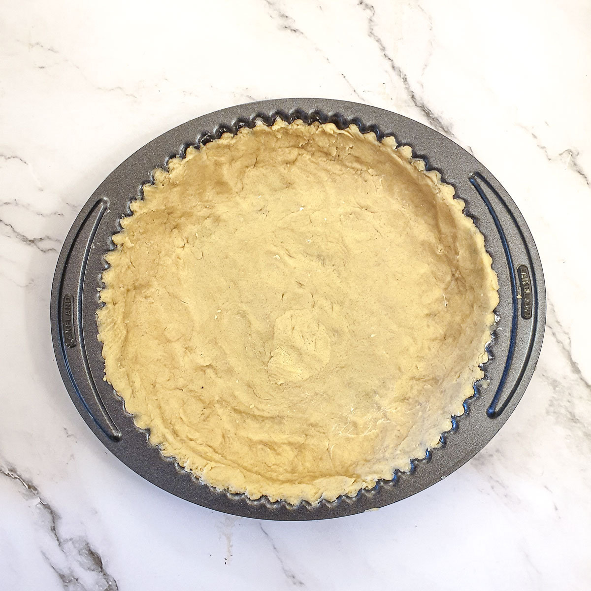 The pastry pressed into a pie dish.