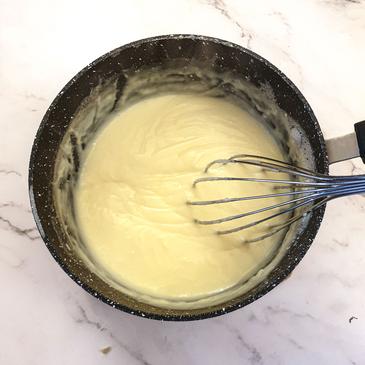 The eggs and flour mixed with the hot milk and thickening in a saucepan