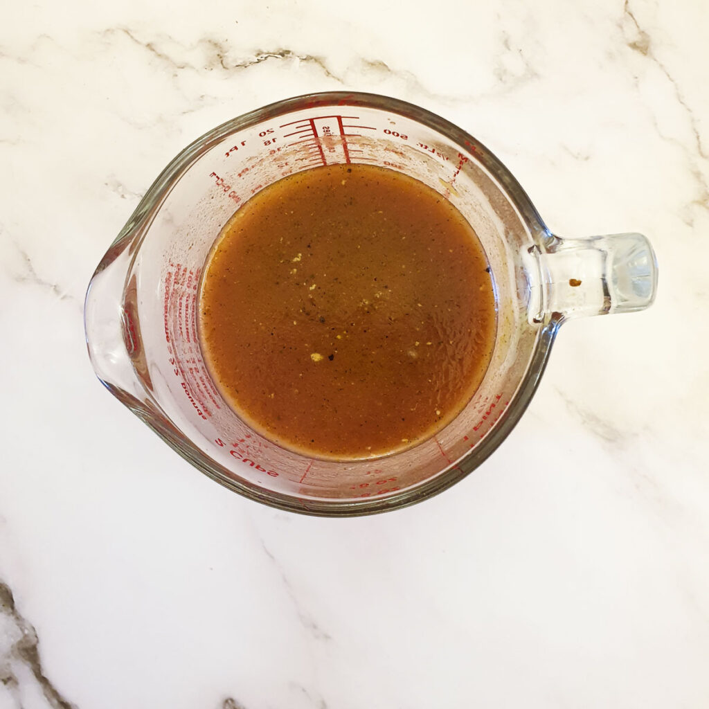 A jug of prepared stock ready to be poured over the topside in the slow-cooker.