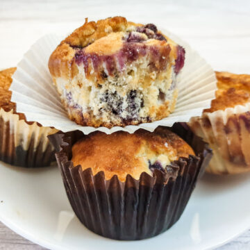 Closeup of a muffin balanced on top of three other muffins.