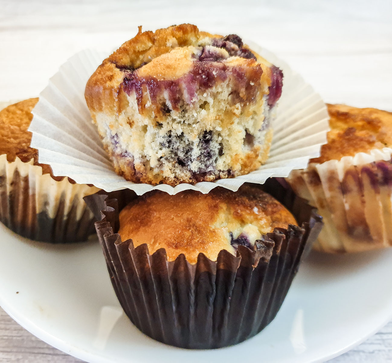 Closeup of a muffin balanced on top of three other muffins.