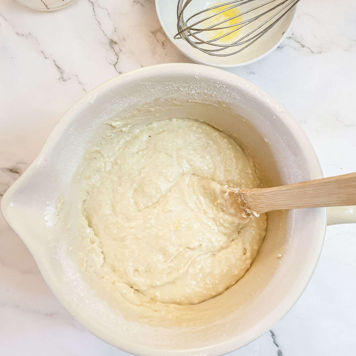 Blueberry muffin batter in a mixing bowl before the blueberries are added.