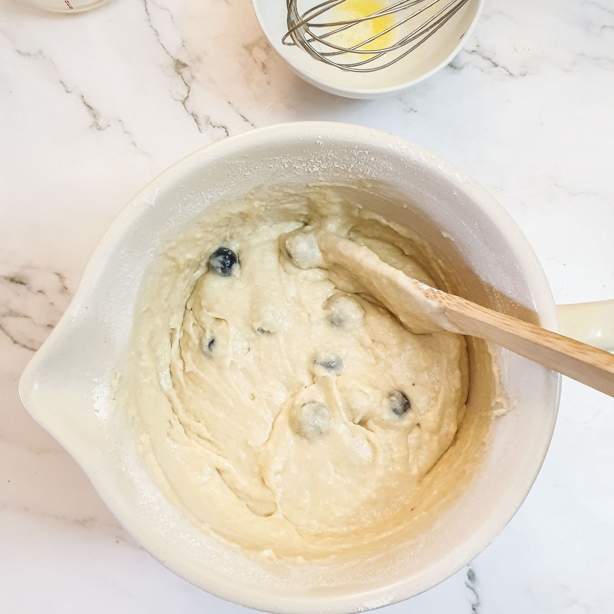 Blueberry muffin batter in a mixing bowl.