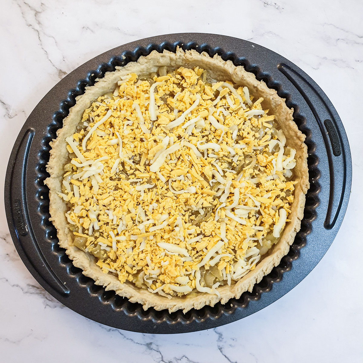 Caramelised onions and grated cheese in a baked pie crust.