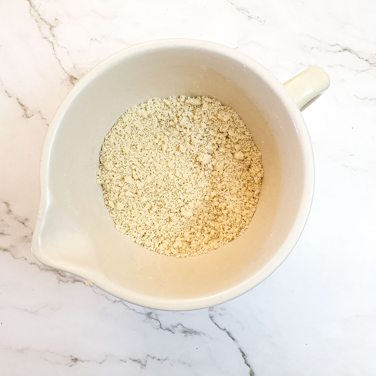 Flour and butter rubbed into breadcrumbs in a mixing bowl.