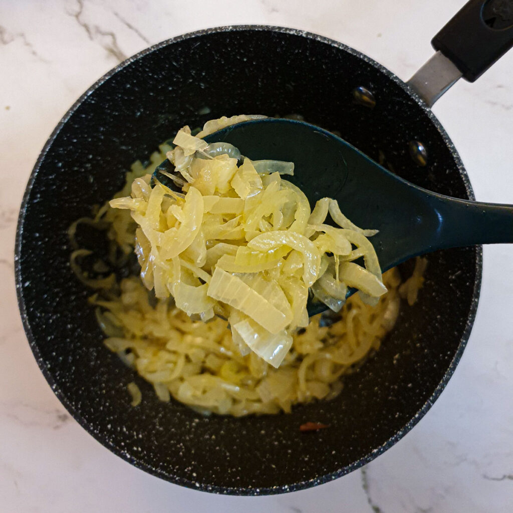 Onions caramelising in a saucepan.
