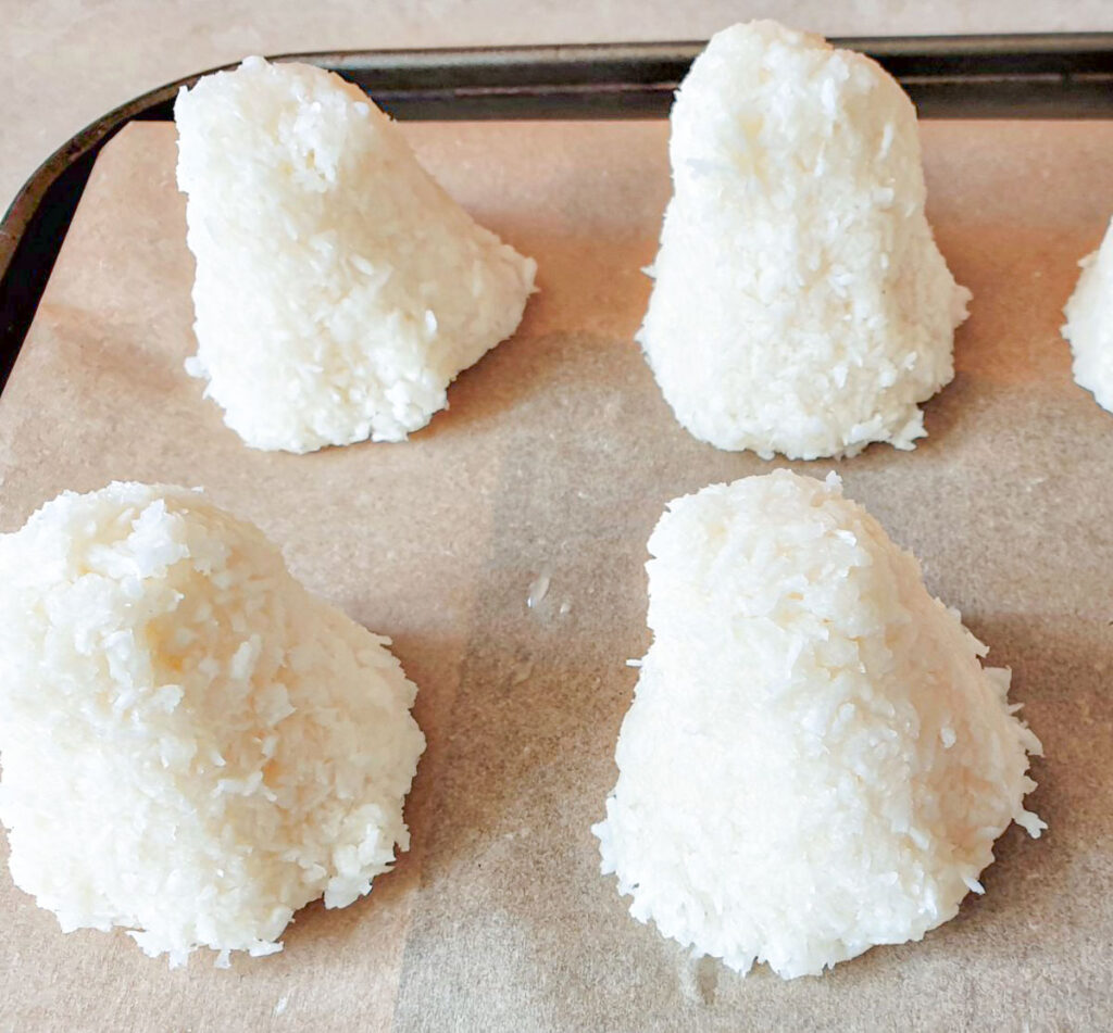 Unbaked coconut macaroons formed into a pyramid shape.
