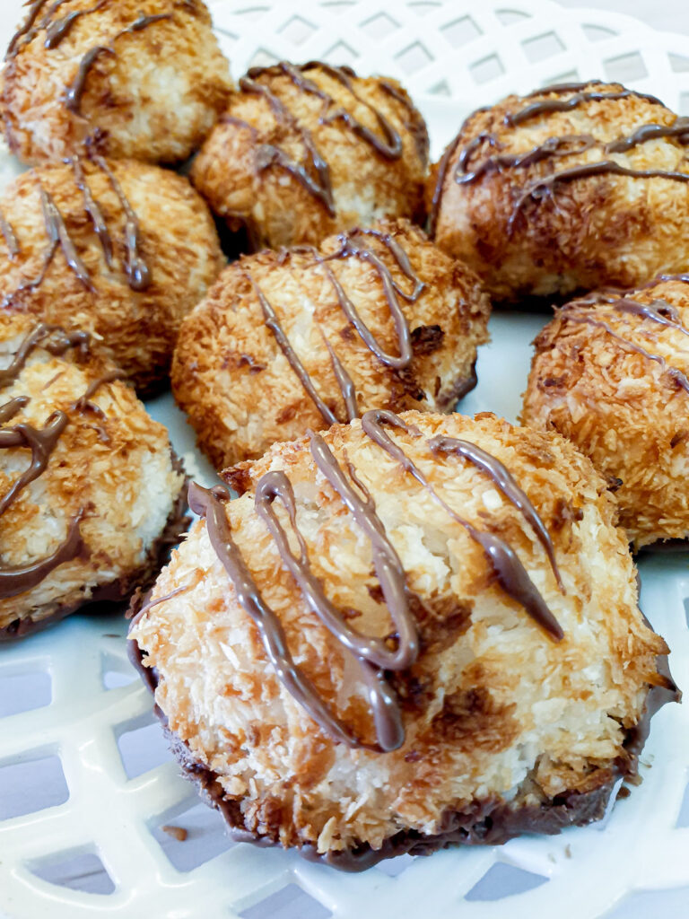 A plate of coconut macaroons drizzled with chocolate.