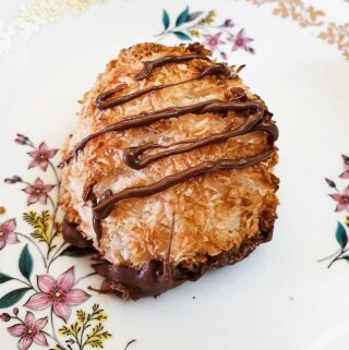 Close up of a coconut macaroon drizzled with chocolate.