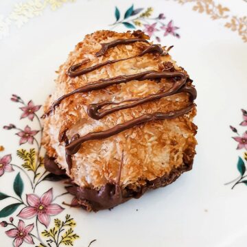 Close up of a coconut macaroon drizzled with chocolate.